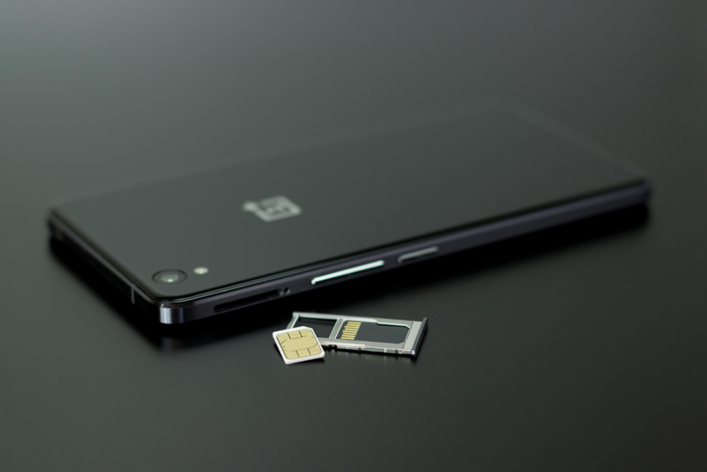 Global version phones explained: A OnePlus Smartphone on Black Table Top with multi-Sim tray ejected.